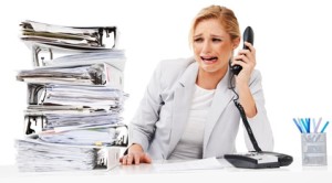An absolutely distraught executive crying into a phone receiver next to a tall pile of files